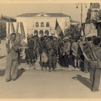 24 aprile 1945, partigiani sfilano in piazza della Vittoria verso quella che diventerà piazza Martiri del 7 luglio 1960 in occasione della Liberazione di Reggio Emilia
