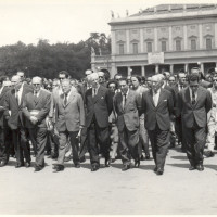 9 luglio 1960, sullo sfondo del teatro Valli inizia il corteo funebre per le vittime dell'eccidio del 7 luglio. Primo a sinistra Umberto Terracini, con la fascia tricolore il sindaco Cesare Campioli, alla sua sinistra Palmiro Togliatti e Ferruccio Parri, con gli occhiali scuri Walter Sacchetti. In seconda fila si riconosce Nilde Jotti (a sinistra di Parri)