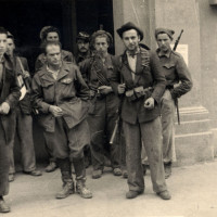 Primavera/estate 1945: un gruppo di partigiani presso l'ingresso di Palazzo Allende nel periodo in cui era anche sede dell'Allied Military Government; al centro, con una mano in tasca, Didimo Ferrari “Eros”